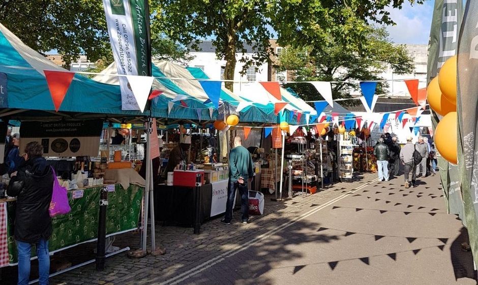 Aylesbury Market Live - people looking at stalls on sunny day with bunting
